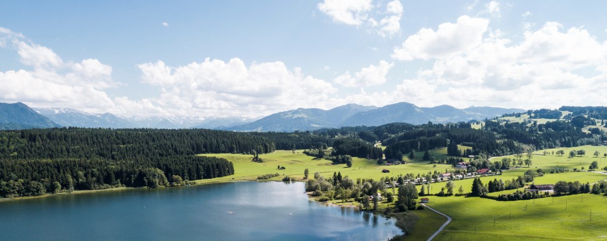 ECOCAMPS - Luftaufnahme vom Camping Zeh am See mit dem Niedersonthofener See und den Allgäuer Alpen im Hintergrund. - Camping Zeh am See